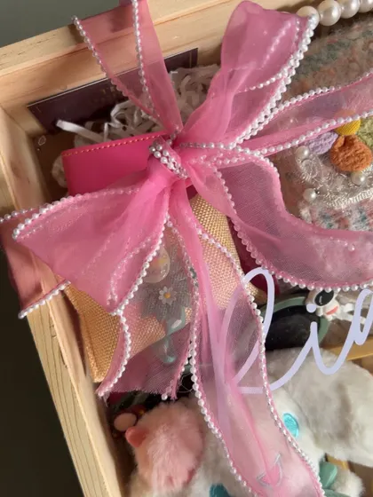 A close-up of the beautiful pearl-edged pink bow that I use to wrap my special hampers for kids.