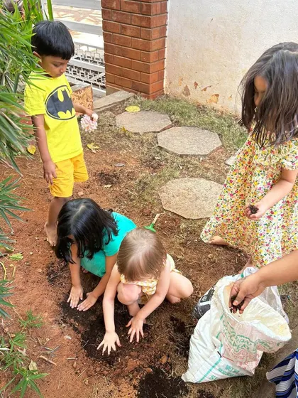 In our school's garden patch, children prepare the soil for planting, connecting with the earth.
