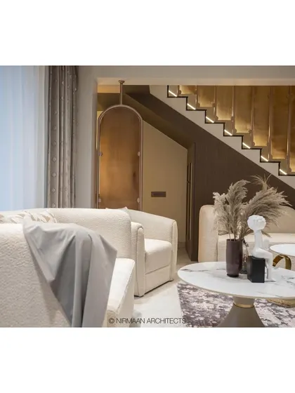A detailed shot of the living room in the Duplex Project, highlighting the textures of the boucle fabric chairs and the elegant marble coffee tables.