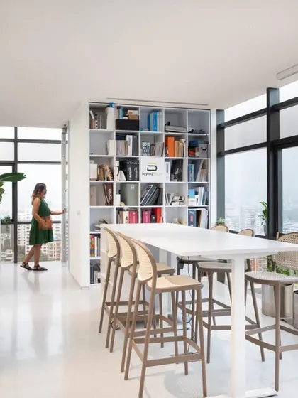 Our office library and material resource center, with a high table for quick meetings or individual work. The large windows provide ample natural light and a connection to the outdoors.
