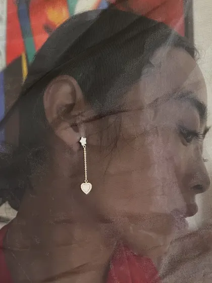The perfect gift for her: a delicate droplet earring featuring a diamond star stud and a dangling heart. It is a sweet and romantic piece for everyday wear.