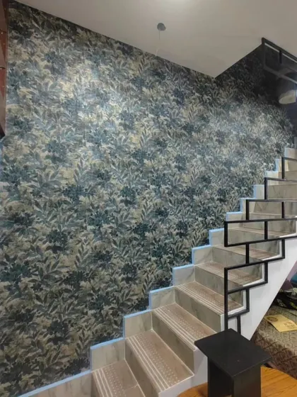A dark, moody floral wallpaper on a staircase wall. The dramatic pattern adds a touch of gothic romance and makes a strong design statement.