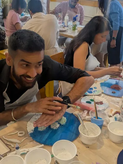 A happy artist at work, smiling as he adds details to his beach painting. The workshop is all about having fun and enjoying the process.