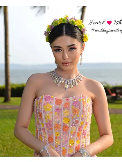 A full view of our modern Mehendi look. The bride wears a delicate yellow diamond necklace that adds a touch of sunshine to her colourful floral outfit, perfect for an outdoor destination wedding.