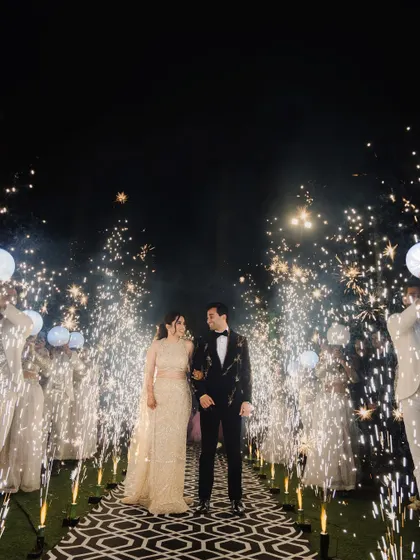 A magical sangeet night entrance, with the couple framed by a pathway of cold pyro sparklers. This shot highlights our expertise in creating dramatic, film-like moments, capturing the energy and celebration of your special evening.