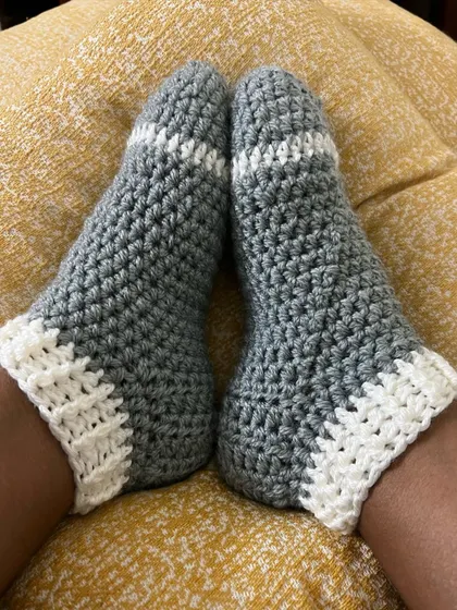 My cozy grey and white crochet socks, perfect for keeping your feet toasty.