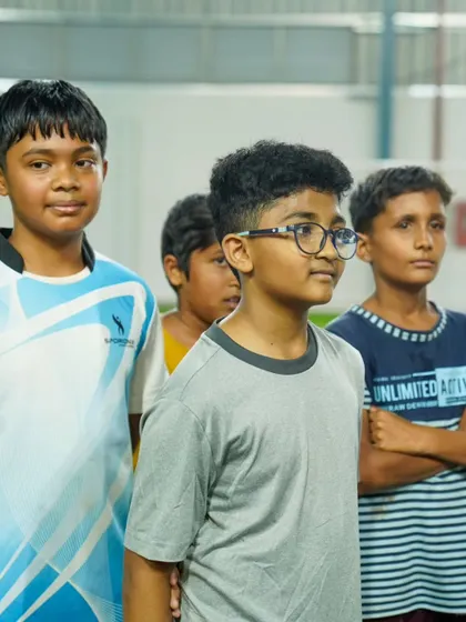 A group of young players listens intently to a coach during the Grassroots Festival.