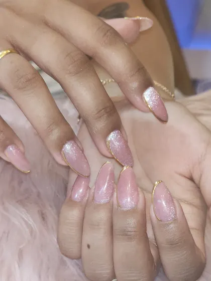 A beautiful example of a glittery pink manicure with a delicate gold chrome outline. This design is perfect for adding a touch of sparkle to your everyday look.