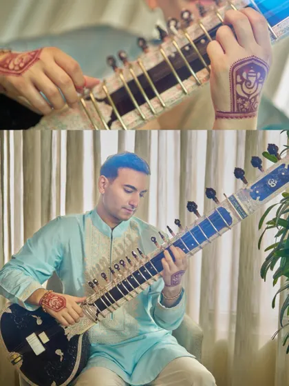 Playing my custom sitar at the Ambani residence, with henna details visible.