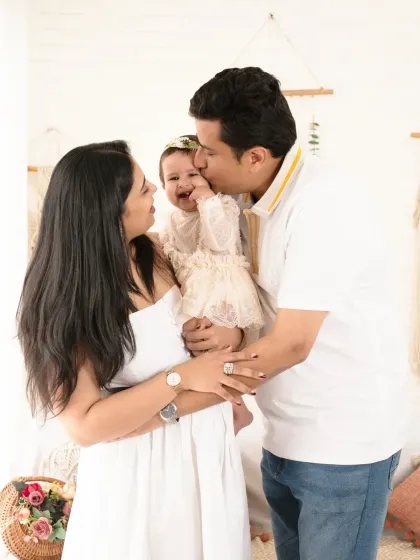 A candid moment of pure family joy, with dad kissing his giggling daughter.
