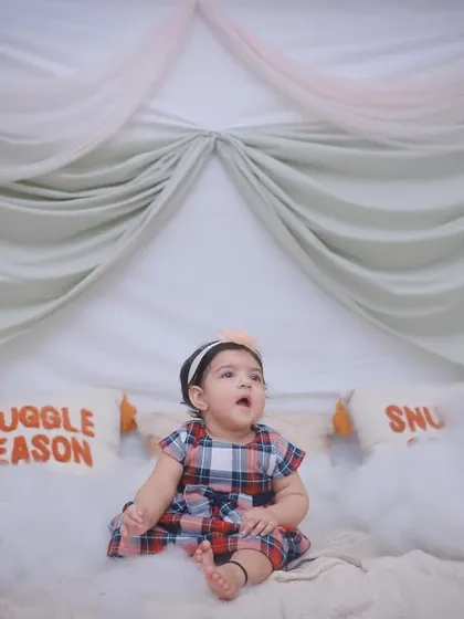 A little girl sitting in a dreamy "Snuggle Season" setup, looking up in awe. We create imaginative scenes for our indoor photoshoots.