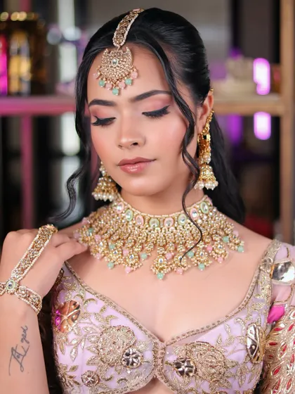 The soft glam of a modern bride. The focus here is on the flawless skin and gently shimmering eye makeup that complements the pastel jewelry.