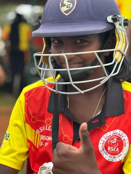 A young female cricketer gives a thumbs-up, ready for her match in the RSCA League.