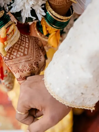 A close-up of the couple holding hands, a simple yet powerful symbol of their union.