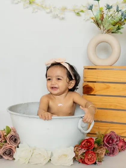Splish, splash, having a blast! This little girl's joyful smile during her floral bath shoot is absolutely infectious.