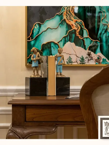 These 'From A to Z' bookends are both functional and artistic. The metal figurines holding up a book add a touch of playful charm to this wooden desk, symbolizing the world of knowledge.