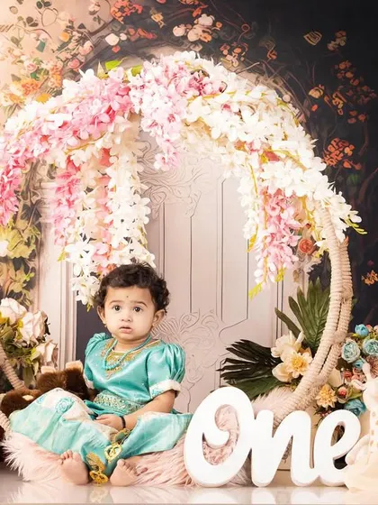 A beautiful first birthday portrait for Riya. This setup features a lovely floral hoop and soft lighting, creating a sweet and timeless image to mark her special milestone.