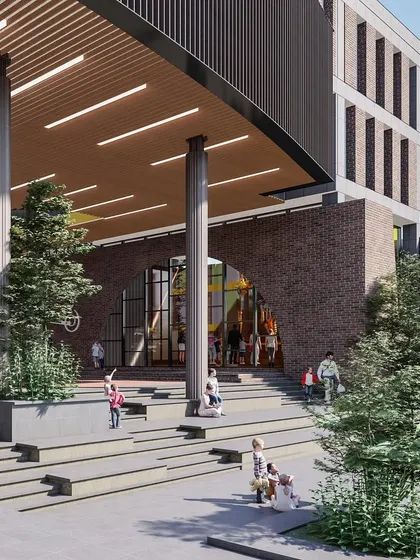 The entrance to Basil School is framed by a large brick arch, leading into the main amphitheater. The design creates a welcoming and playful transition from the outside world into the learning environment.