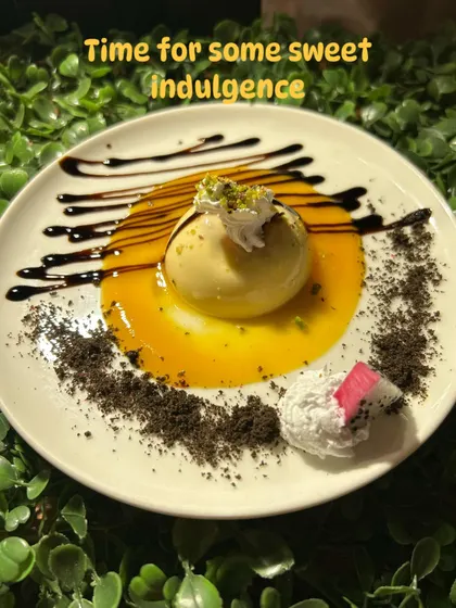 Time for some sweet indulgence. This artistic dessert features a sphere of mango mousse on a pool of mango puree, drizzled with chocolate and garnished with pistachio dust.