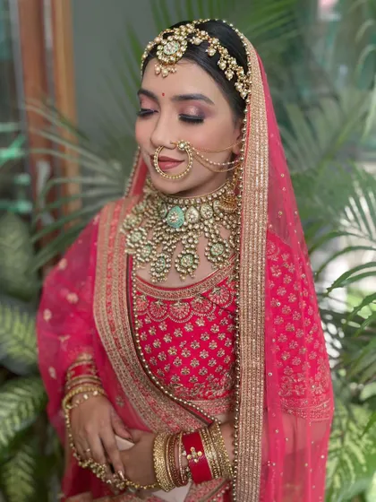 The full look shows how the mint green jewellery, including the sheesh patti, stands out against the pink outfit. This is a perfect example of modern bridal styling.