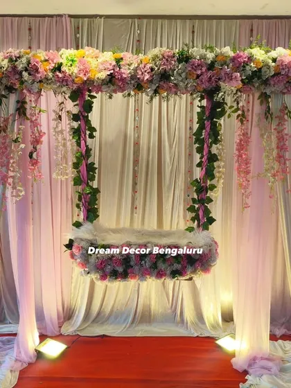 A closer view of the hanging floral cradle. The mix of pink flowers and cascading wisteria, all artificial, creates a dreamy and long-lasting look that clients love.