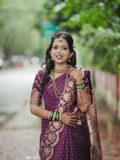A full-length portrait for an engagement. The bride's classic look, with a beautifully draped saree and traditional gold jewelry, is timeless and sophisticated.