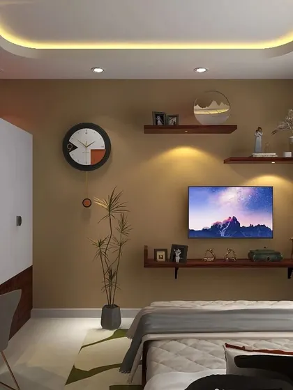 A cozy and compact bedroom design that cleverly integrates a TV unit with floating shelves. The warm wall color and false ceiling with cove lighting make the space feel inviting.