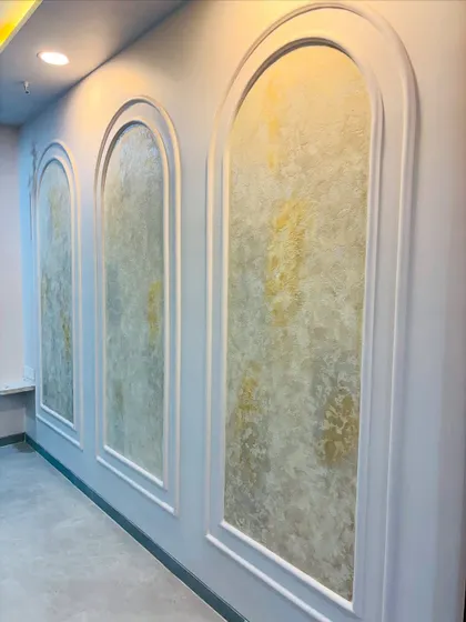 The combination of spotlights and ambient lighting highlights the beautiful golden tones in the textured wall paint.
