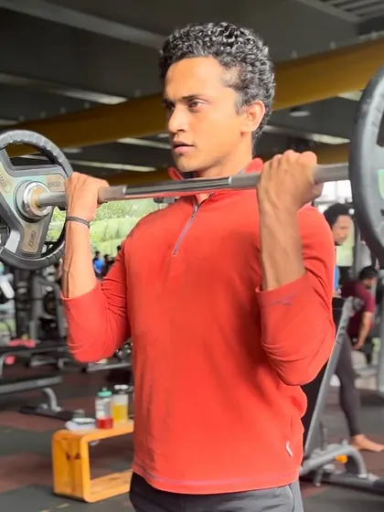 A member performs a barbell front raise, an excellent exercise for shoulder development. Our spacious free-weight area provides ample room for a wide variety of strength training exercises.