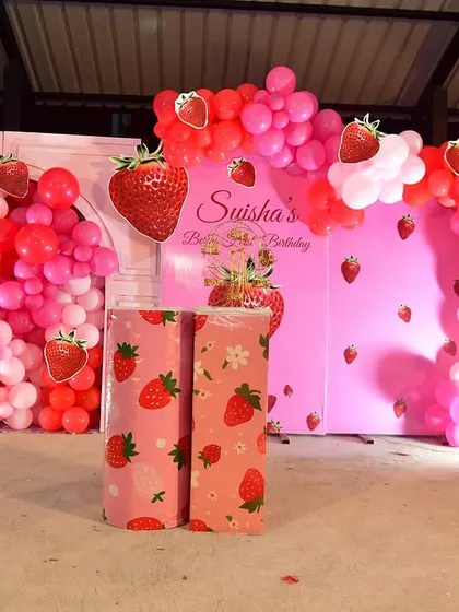 A 'Berry First Birthday' with a cute strawberry theme. The decor is filled with shades of red and pink, and lots of strawberry cutouts.