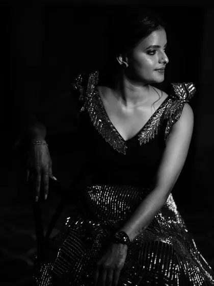 A timeless black and white portrait of a bride in her reception gown. The dramatic lighting creates a moody and sophisticated look, highlighting her elegance.