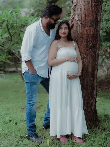 A beautiful portrait of the couple by a tree, showcasing their bond. The soft natural light enhances the peaceful atmosphere of the maternity shoot.