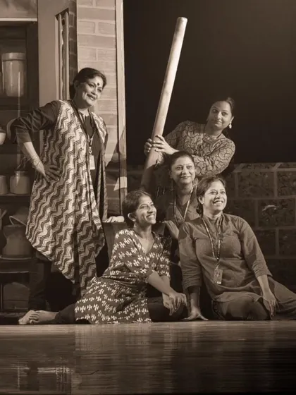 The cast of "Songs of the Millstone" posing with props on the set. This production blended classical dance with folk themes and theatrical elements.
