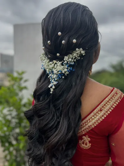 A gorgeous half-up, half-down style with a cascade of baby's breath flowers. This is a perfect look for a romantic, bohemian-themed event.
