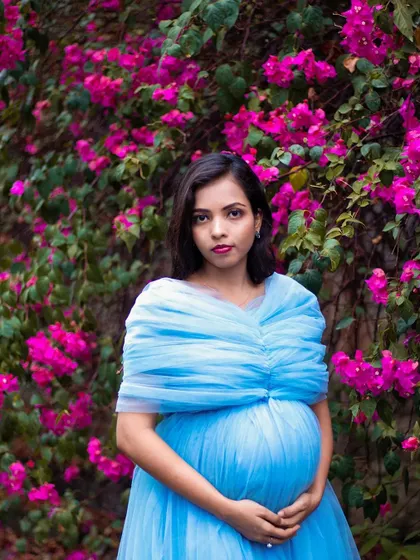 A close-up portrait of a mom-to-be in the blue tulle gown, showing how the draped neckline beautifully frames the face and shoulders.