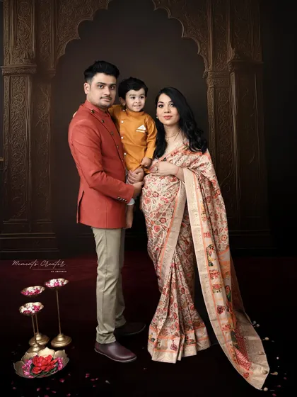 A complete family portrait with a traditional Indian aesthetic. The composition, with the family framed by an archway, creates a feeling of warmth and togetherness.