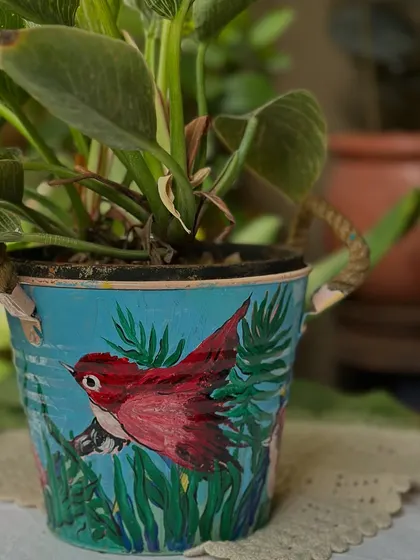 A new set of planters painted by my dearest mom, this one featuring a red bird in a lush green setting.