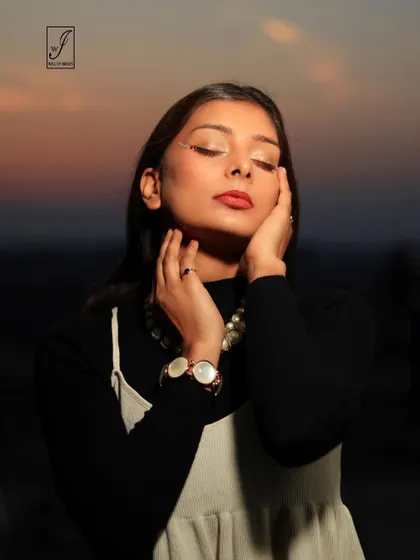 An intimate beauty shot taken during sunset, with the soft light highlighting the model's features and the subtle shimmer on her eyelids.