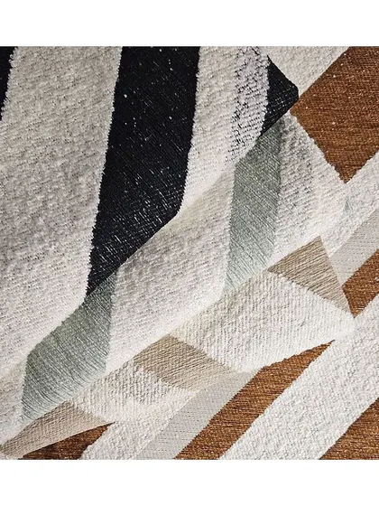 This 'SLALOM' jacquard fabric features wide, textural stripes. The varied weave adds a three-dimensional quality, making it a dynamic choice for upholstery or heavy curtains.