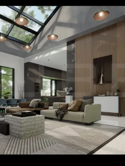 This angle shows how we create cohesive, open-plan living areas. The living room, dining space, and kitchen flow into one another under a vaulted ceiling with a skylight, making the entire area feel spacious and connected.