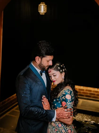 An intimate portrait of the couple embracing in a softly lit archway.