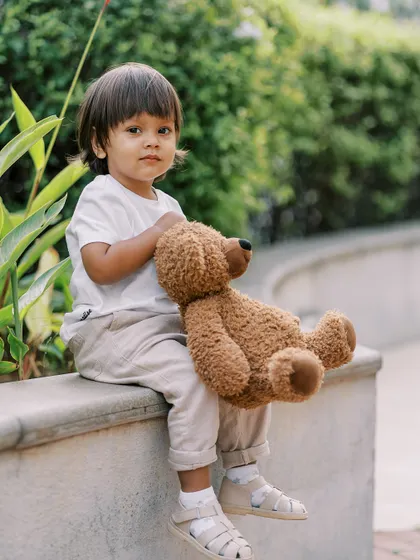 A little boy sitting with his teddy bear. A quiet, sweet portrait that captures his serious side.