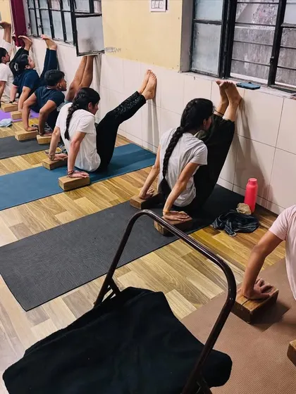 Students use chairs and blocks to work on leg strength and flexibility. We believe in using props to support and enhance the practice for everyone.