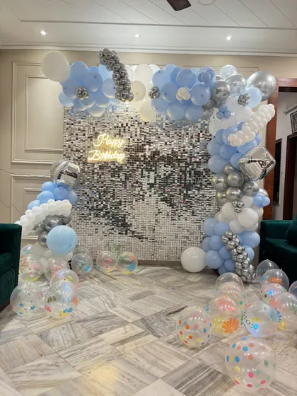 A full view of the cloud-themed shimmer wall decoration, showing the scattered transparent balloons on the floor.