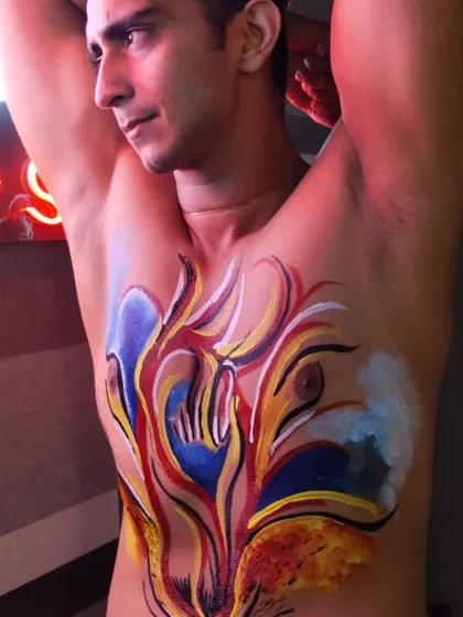 A powerful abstract design painted on a participant's chest. This kind of expressive art can be a profound experience, allowing for a new form of communication and self-discovery.