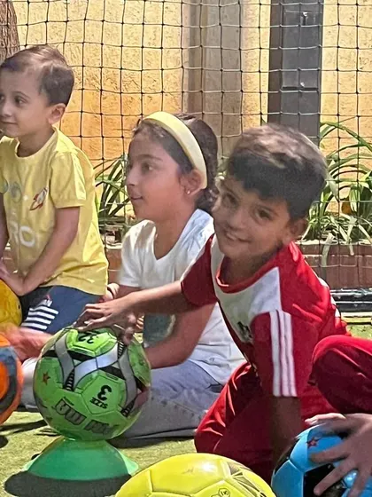 A close-up of children's faces as they listen to their coach. Their engaged expressions show that they are captivated and learning.