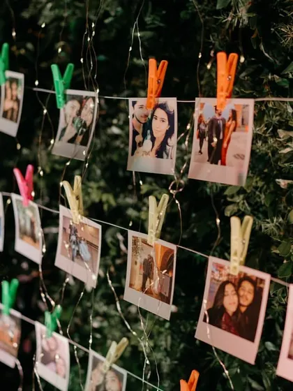 A personalized photo wall with polaroids of the couple's journey, clipped to strings of fairy lights. It's a sweet and interactive detail for guests to enjoy.