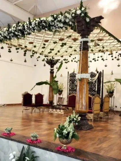 A side view of the mandap during setup, highlighting the craftsmanship involved in placing each floral element to achieve a look of natural abundance and elegance.
