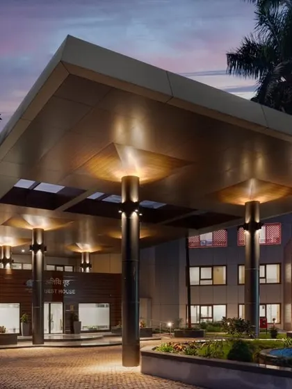 The entrance canopy of the renovated guesthouse was designed to be both grand and inviting. The warm, recessed lighting and strong structural pillars create a powerful statement of arrival for guests.