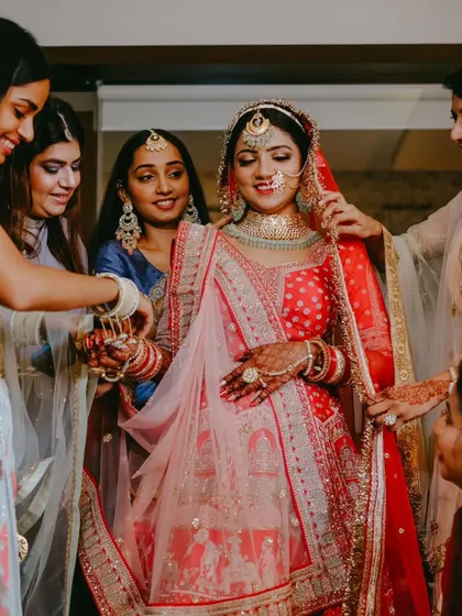 The bridesmaids help adjust the bride's veil, a classic wedding day shot.